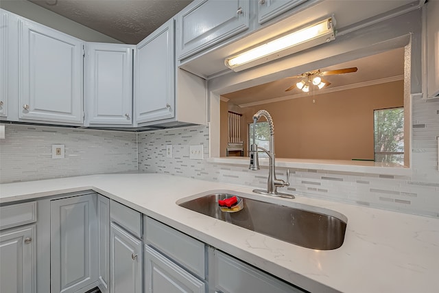 kitchen with crown molding, sink, tasteful backsplash, and a wealth of natural light