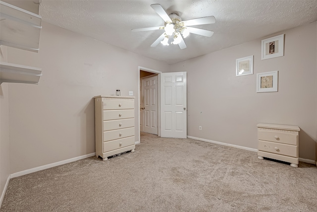 unfurnished bedroom with light carpet, a textured ceiling, and ceiling fan