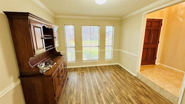 entryway with crown molding, hardwood / wood-style flooring, and a textured ceiling