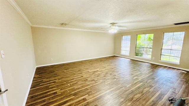 spare room with dark wood-type flooring, crown molding, a wealth of natural light, and ceiling fan