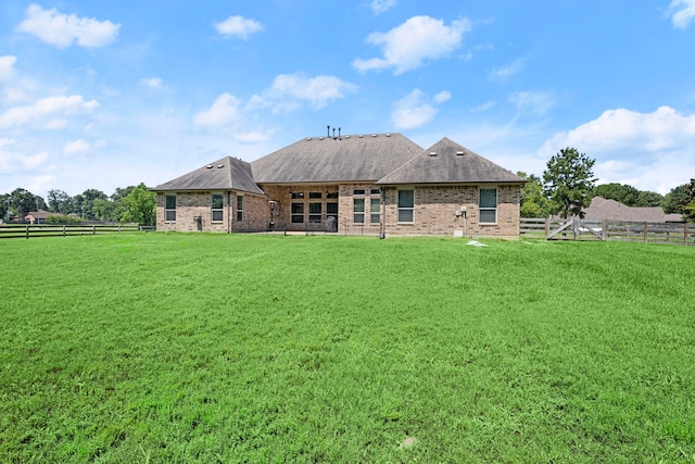 rear view of property featuring a lawn