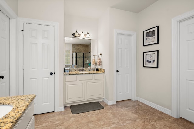 bathroom featuring tile floors, a shower with shower door, and vanity