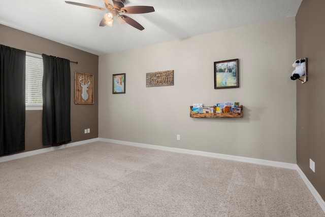 carpeted spare room with ceiling fan