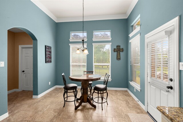 tiled dining area featuring an inviting chandelier and crown molding