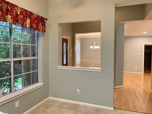 empty room featuring light wood-type flooring and an inviting chandelier