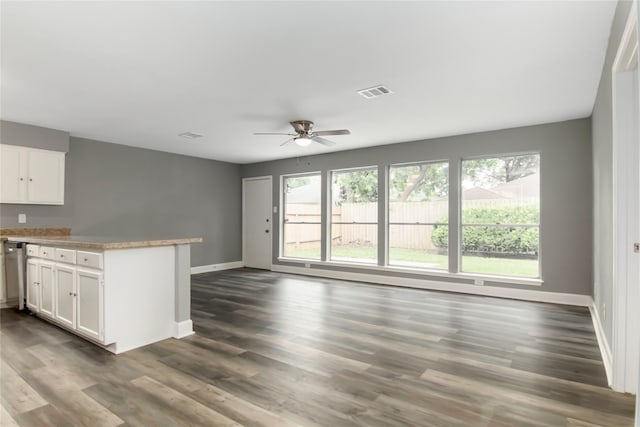 kitchen with dark wood-type flooring, ceiling fan, and white cabinets