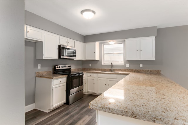 kitchen with white cabinetry, sink, light stone counters, appliances with stainless steel finishes, and dark wood-type flooring