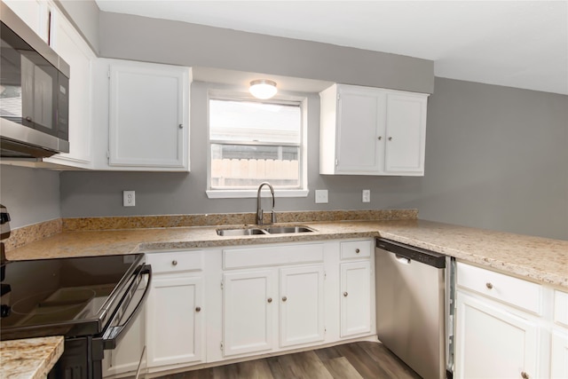 kitchen with dark wood-type flooring, sink, white cabinets, and stainless steel appliances