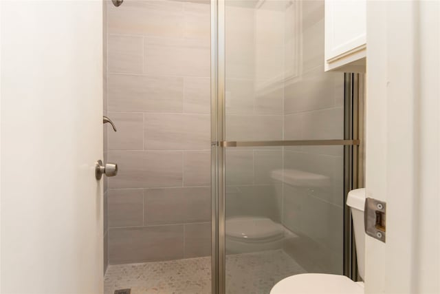 bathroom with toilet and an enclosed shower