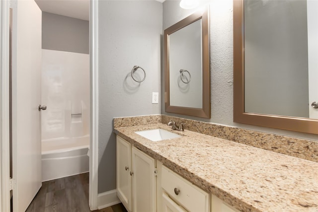 bathroom featuring shower / bathtub combination, vanity, and hardwood / wood-style flooring