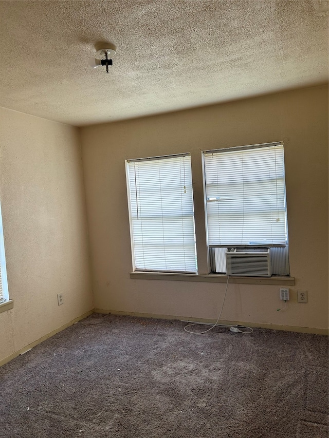 empty room with a textured ceiling and carpet flooring