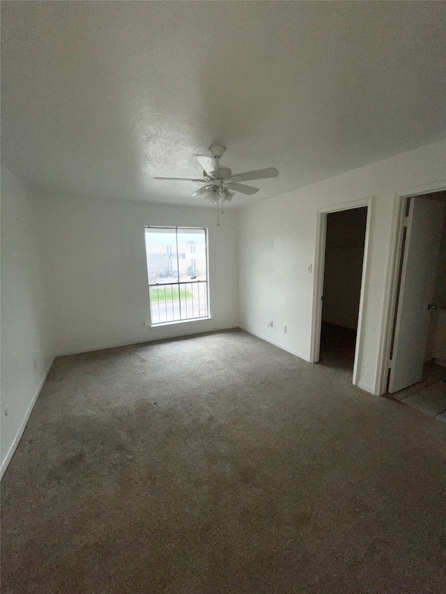 carpeted spare room with a textured ceiling and ceiling fan