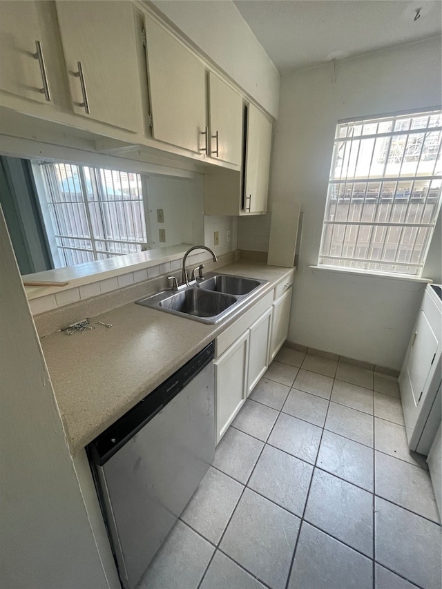 kitchen featuring sink, light tile patterned flooring, and stainless steel dishwasher