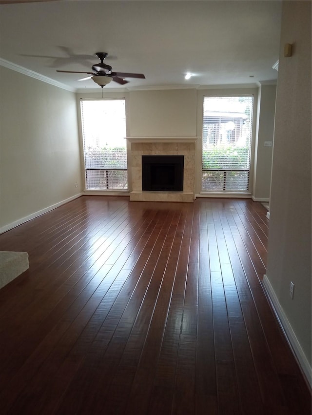 unfurnished living room featuring a fireplace, dark wood-type flooring, ceiling fan, and ornamental molding