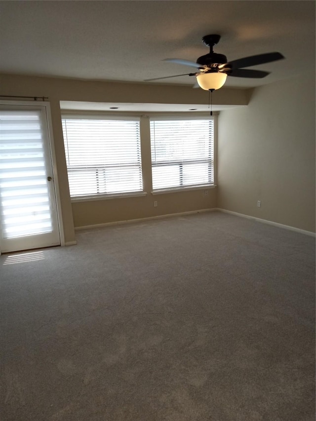 spare room with carpet floors, ceiling fan, and a healthy amount of sunlight