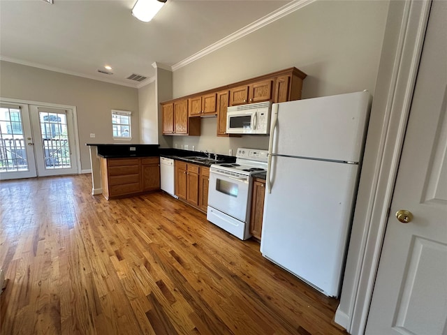 kitchen featuring kitchen peninsula, french doors, white appliances, crown molding, and light hardwood / wood-style floors