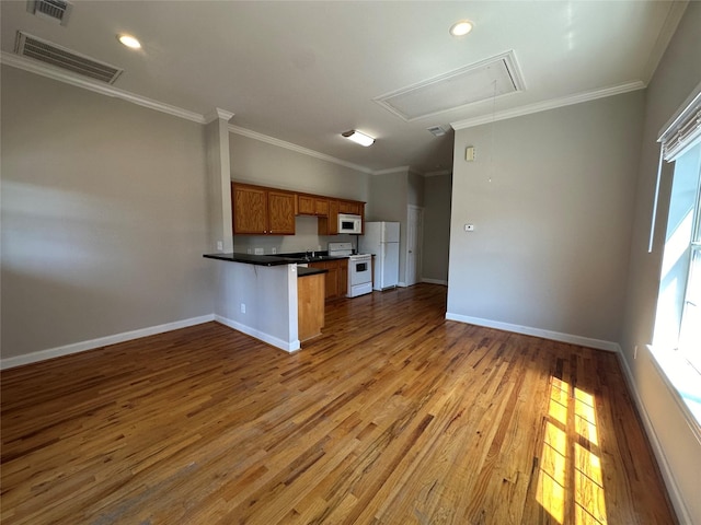 kitchen featuring crown molding, light wood-type flooring, white appliances, and kitchen peninsula