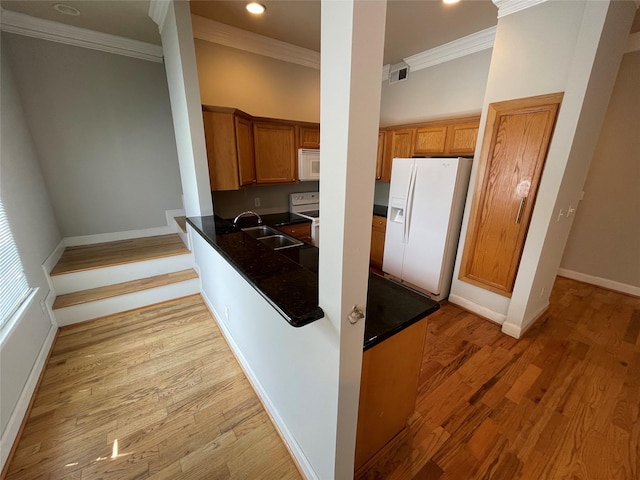 kitchen with light hardwood / wood-style floors, white appliances, sink, and ornamental molding