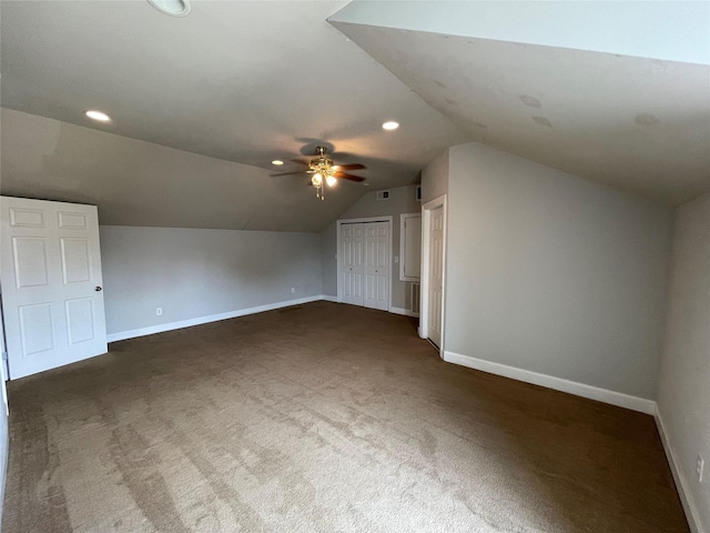 additional living space featuring dark carpet, vaulted ceiling, and ceiling fan