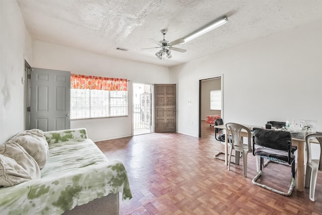 bedroom featuring ceiling fan, parquet floors, a textured ceiling, and access to outside