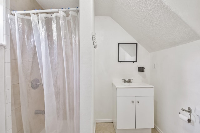 bathroom with vanity, curtained shower, lofted ceiling, and a textured ceiling