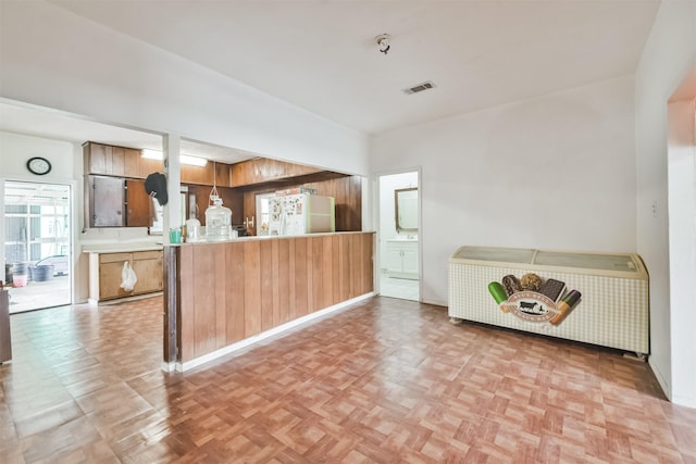 kitchen with kitchen peninsula, light parquet flooring, and white refrigerator