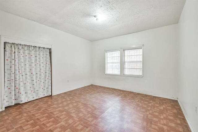 unfurnished bedroom featuring a textured ceiling and light parquet floors