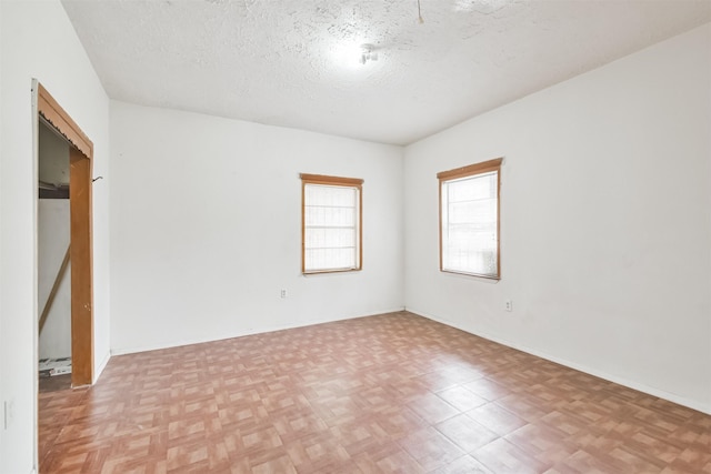 unfurnished room featuring a textured ceiling and light parquet floors