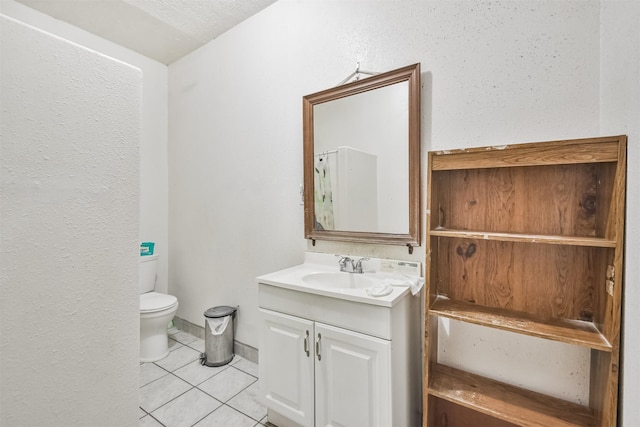 bathroom featuring tile patterned floors, vanity, a textured ceiling, and toilet