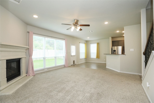 unfurnished living room featuring ceiling fan and light carpet