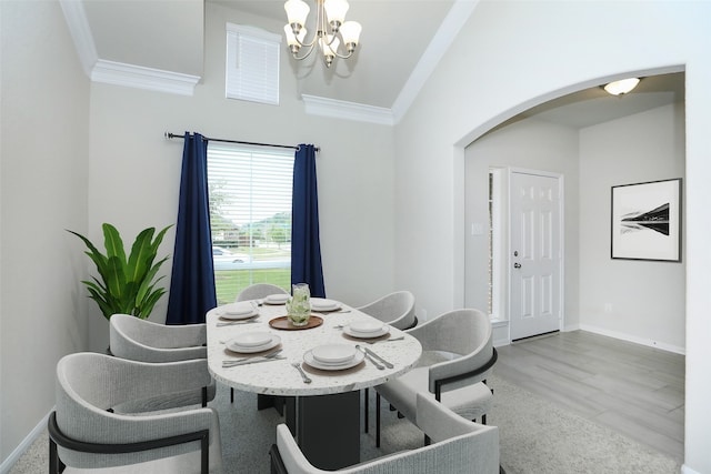 dining space featuring a notable chandelier, ornamental molding, and light hardwood / wood-style flooring