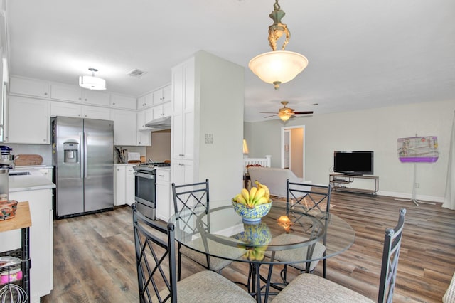 dining area with ceiling fan and dark hardwood / wood-style flooring