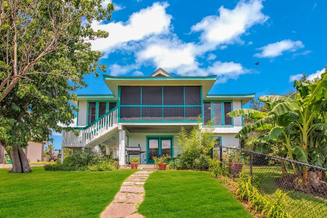 beach home with a front lawn and a sunroom