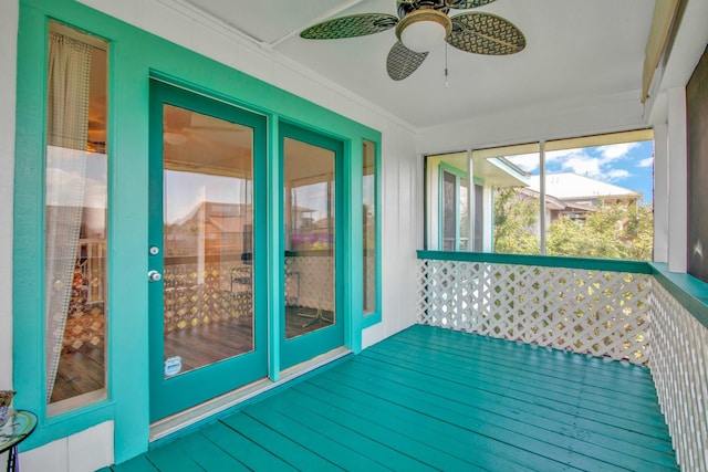 unfurnished sunroom featuring ceiling fan