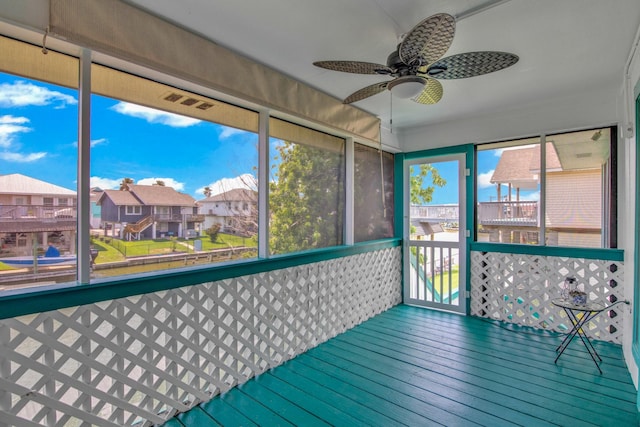 unfurnished sunroom with ceiling fan and a wealth of natural light