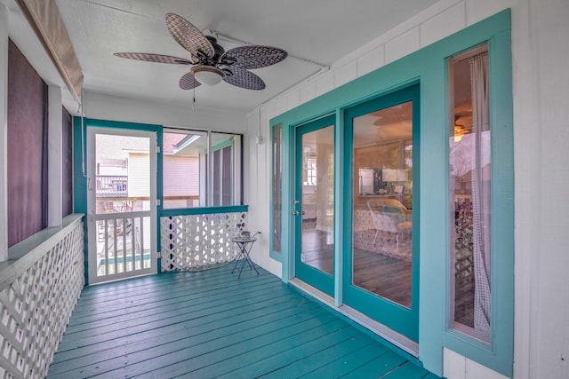 unfurnished sunroom featuring ceiling fan