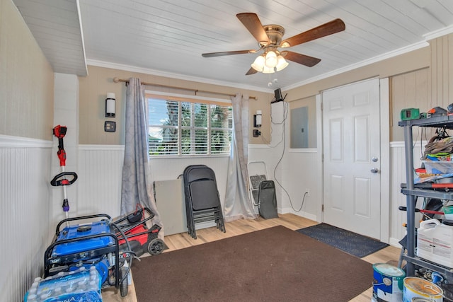 misc room with light wood-type flooring, electric panel, ceiling fan, and ornamental molding