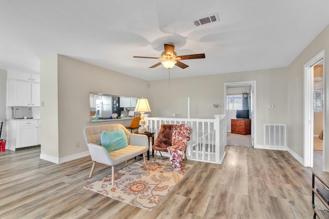 sitting room with light hardwood / wood-style floors and ceiling fan