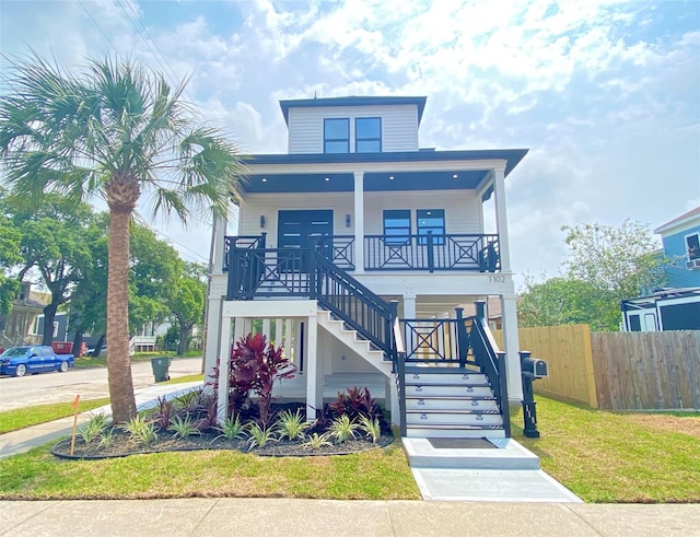 coastal inspired home featuring a front yard and a porch