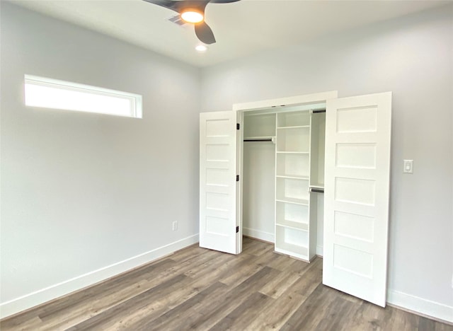 unfurnished bedroom featuring ceiling fan, dark hardwood / wood-style flooring, and a closet