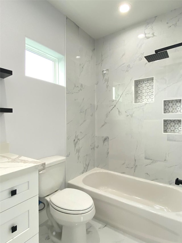 full bathroom featuring tiled shower / bath, vanity, and toilet