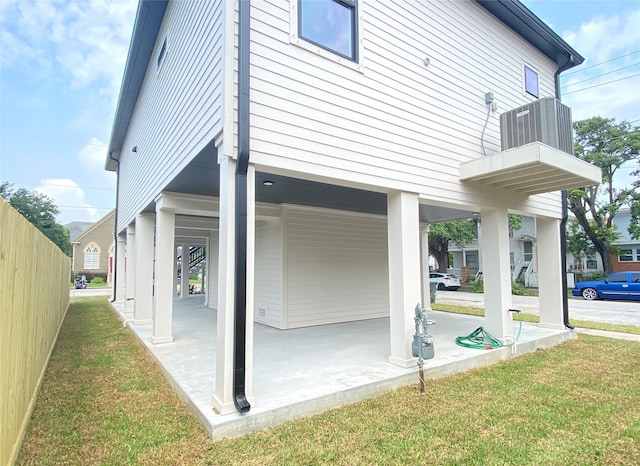 view of property exterior with a lawn, central AC unit, and a patio area