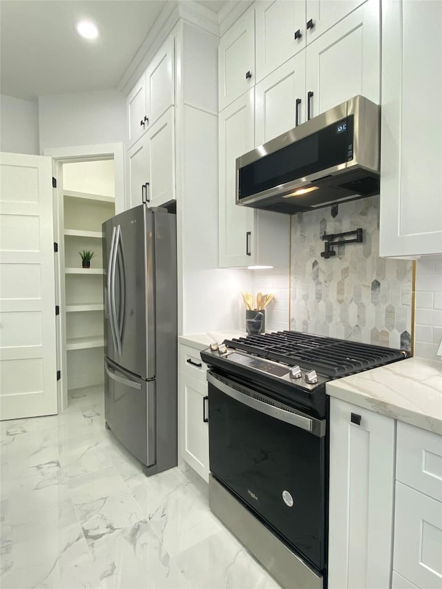 kitchen with light stone counters, appliances with stainless steel finishes, and white cabinets