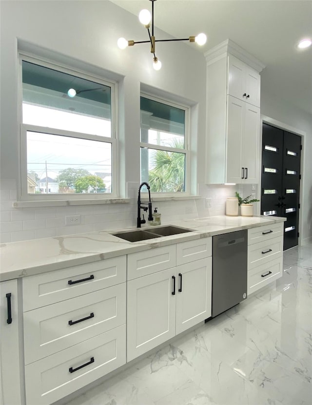 kitchen featuring dishwasher, sink, white cabinets, and backsplash