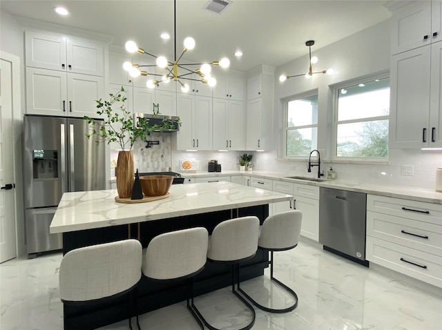 kitchen featuring sink, decorative light fixtures, a center island, and appliances with stainless steel finishes