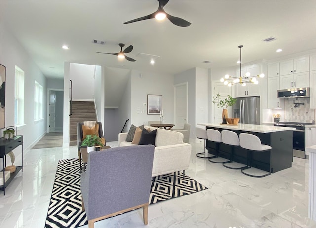 living room featuring ceiling fan with notable chandelier