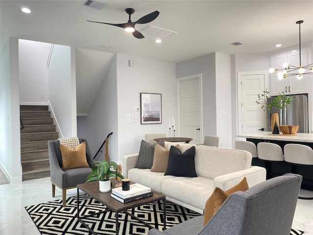 living room featuring ceiling fan with notable chandelier