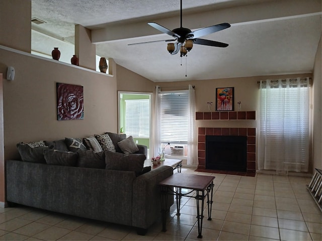 living room featuring lofted ceiling with beams, a healthy amount of sunlight, light tile patterned flooring, and a textured ceiling