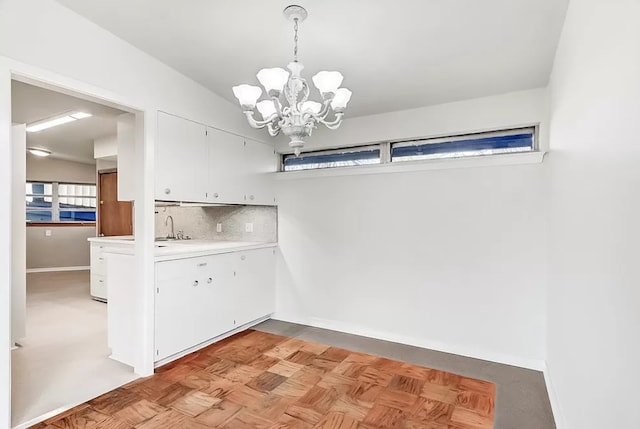 laundry room with light parquet floors and an inviting chandelier