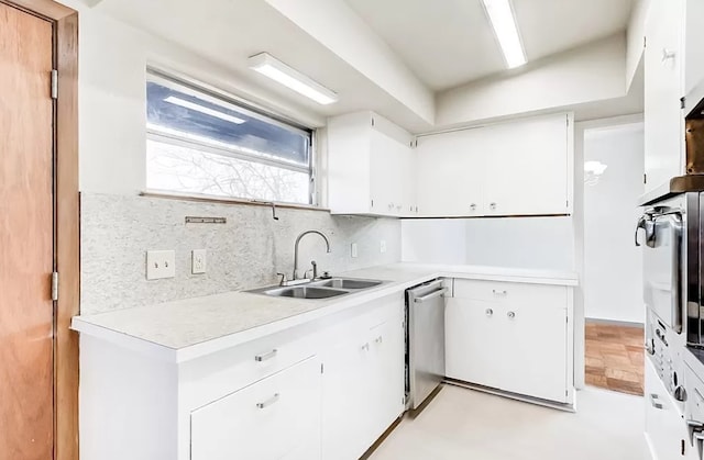 kitchen featuring white cabinets, sink, tasteful backsplash, and stainless steel dishwasher